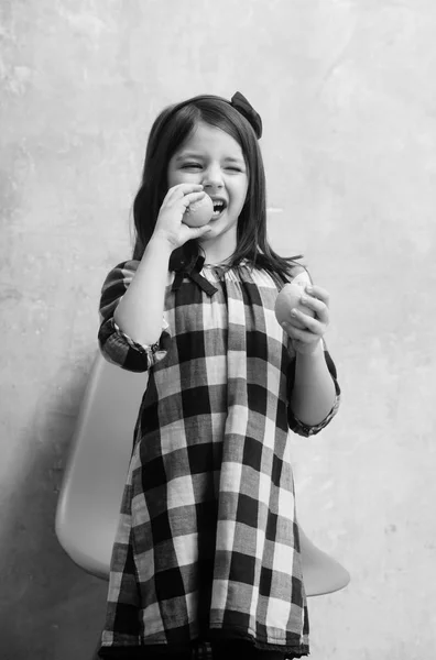 Menina bonito com olhos piscando comer limões — Fotografia de Stock
