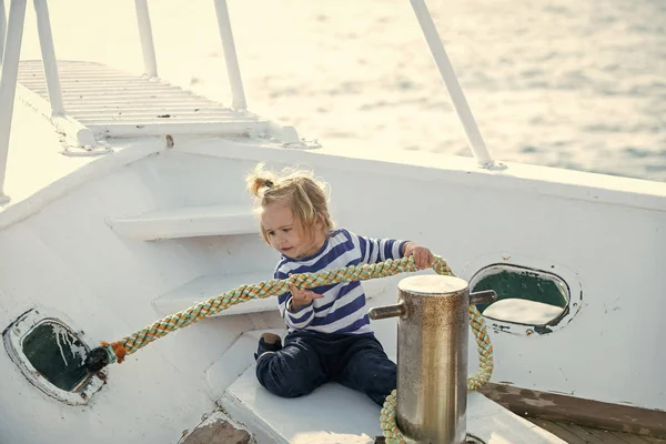 Criança sentada e amarração corda no barco branco — Fotografia de Stock