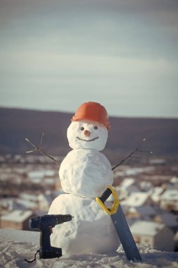 Bina ve onarım çalışmaları. Mutlu tatil ve kutlama. Kask içinde kışın kardan adam Oluşturucu. Noel veya Noel dekorasyon. Kar gördüm ve tornavida ile yeni yıl kardan adam.