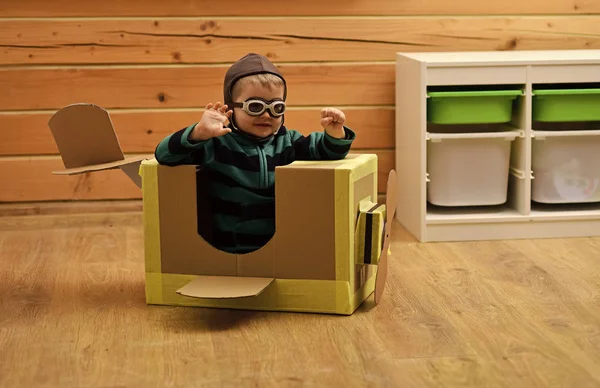Мальчик играет в картонный самолет, детство . — стоковое фото