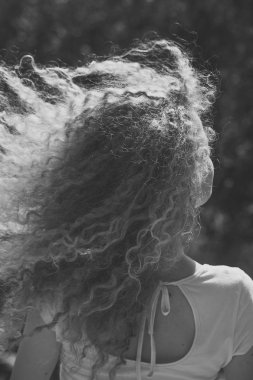Dışarıdaki kıvırcık saçlı kadın.