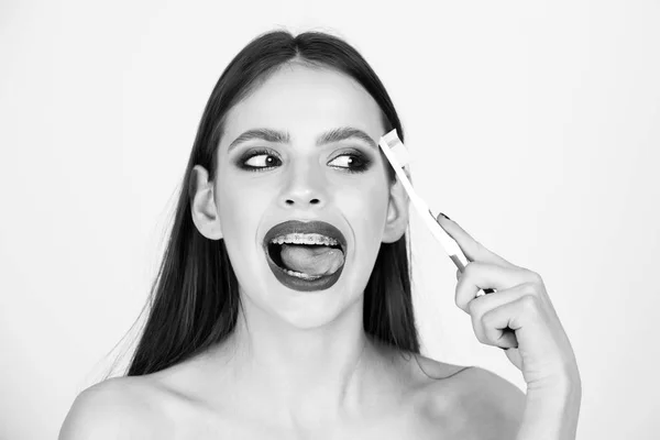 Menina com aparelho de dentes e escova, tem maquiagem elegante — Fotografia de Stock