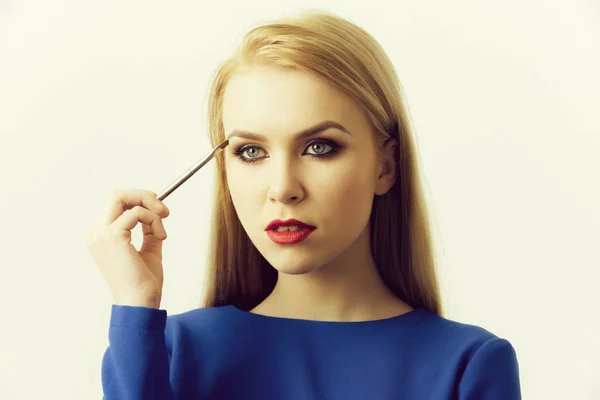 Woman with makeup brush applying eyeshadow