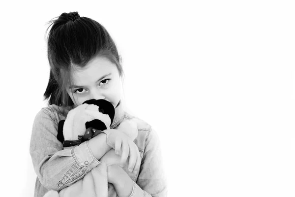 Малыш, очаровательная девушка обнимает симпатичную игрушечную собаку — стоковое фото