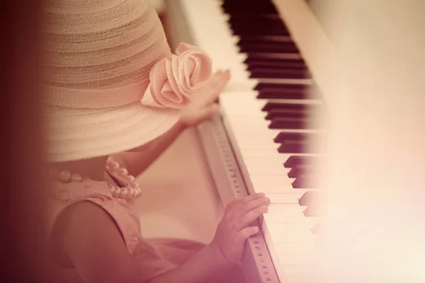 Kid in vintage pink hat, dress, bead necklace play piano — Stock Photo, Image