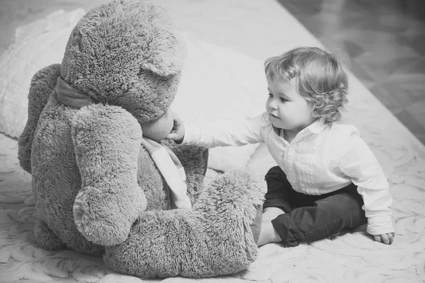 Babyjongen en teddy bear op tapijt — Stockfoto