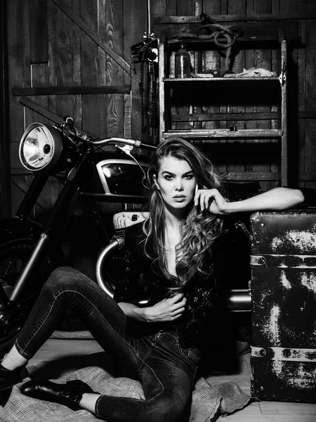 Сексуальная девушка байкер с чемоданом на мотоцикле держать мобильный телефон — стоковое фото