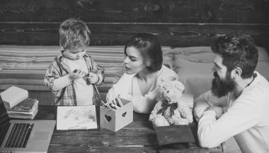 Anne oğlu, ahşap duvar arka plan öğretir. Çocuk Anne ve babamla dikkat dinliyor. Evde eğitim kavramı. Ebeveynler öğretim çocuk, konuşma. Aile eğitimi oğulları hakkında umurunda değil..