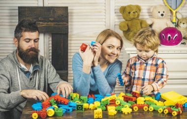 evde anne ile küçük boy oynayın. Baba ve anne ile Çocuk oyun kurucu. mutlu çocukluk. Bakım ve geliştirme. Aile ve çocuk günün kutlu olsun. Baba ve anne küçük çocuk. Benim ailem