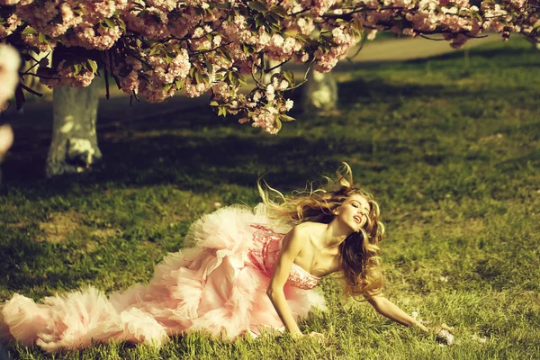 Sensuele vrouw op gras met bloom — Stockfoto