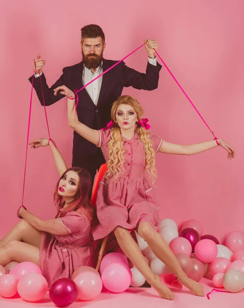 Retro meisjes en master in de partij ballonnen. Creatief idee. Liefde driehoek. Gek meisjes en man op roze. Halloween. vintage mode vrouwen pop en man. feestdagen en poppen. dominantie en afhankelijkheid — Stockfoto