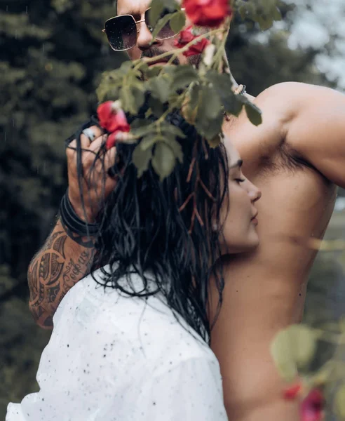 Amantes de la primavera en el jardín floreciente. Abrazos juntos y tacto sensual. Hermosa pareja feliz beso y abrazos. Pareja de verano y momento erótico. Pareja al aire libre en árboles florecientes. Amantes de la belleza en flores . —  Fotos de Stock