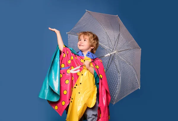 Děti se baví s listí podzim. Veselý kluk v pláštěnce s Barevný deštník. Hezký malý chlapík v přípravě na podzim. Prodej za celou podzimní kolekci, neuvěřitelné slevy. — Stock fotografie