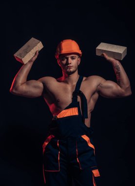 Bina büyük şeyler kurmak. İnşaat işçisi veya Oluşturucu site oluşturma, iş yerinde. Çimento işçi. Adam işçi tuğla kas elinde tut. Kaslı adam duvar çalışması yok.