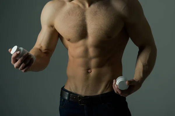 La mia dieta. Alimentazione vitaminica. L'uomo forte tiene bottiglie di vitamina. Uomo con sei addominali. Stimolare la crescita muscolare con steroidi anabolizzanti. L'ormone anabolico aumenta la forza muscolare. Dieta sana — Foto Stock