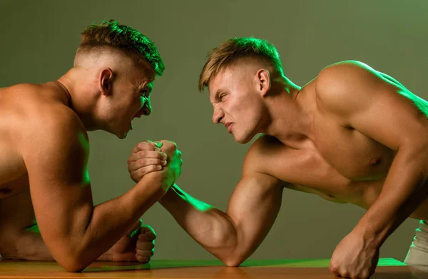 Revanche dans le sport. Jumeaux hommes en compétition jusqu'à la victoire. Compétences en force. Twins concurrents bras de fer. Hommes concurrents essaient de gagner la victoire ou la vengeance. Potentiel de force — Photo