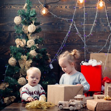 Çocuklar hediye ile oynuyor. Yeni yıl arifesinde. Noel hediye kutusu ve mutlu bir aile. Çocuklar Noel hediyeleri açma. Kış akşam evde. Noel hediye kutusu ile mutlu gülümseyen çocuk.