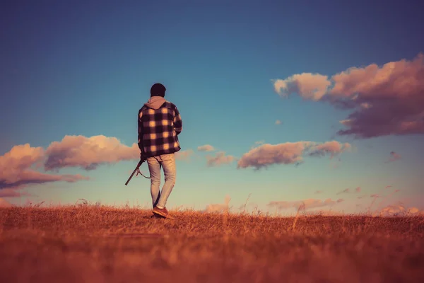 Caza ilegal cazador furtivo en el bosque. Rifle Hunter Silhouetted en Beautiful Sunset. Temporada de caza de otoño . — Foto de Stock