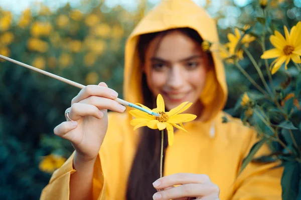 Chica pintando Flor. Mujer sensual de primavera con flor. Concepto de niña naturaleza. Pintura de primavera. Humor amarillo de primavera. Flor en las manos. —  Fotos de Stock