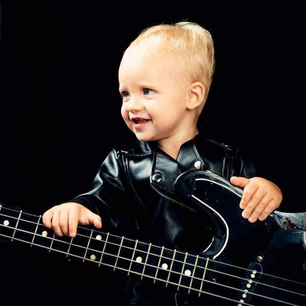 Music is what feelings sound like. Adorable music fan. Little rock star. Child boy with guitar. Little guitarist in rocker jacket. Rock style child. Rock and roll music performer. Small musician