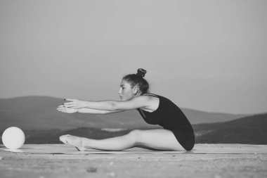 Yeşil topu ile siyah spor giyim kadın jimnastikçi.