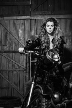 Deri ceketli vintage motosiklet üzerinde oturan seksi güzel motorcu