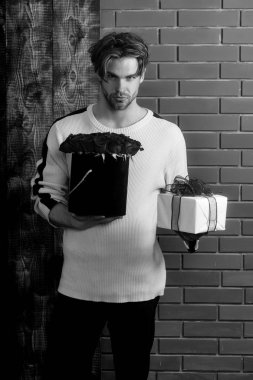 sakallı adam tutar kırmızı gül çiçek ve hediye kutusu