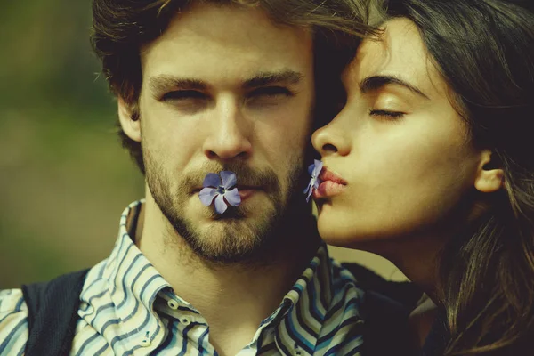 Kız ve erkek arkadaşı ağız içinde mavi çiçekli — Stok fotoğraf