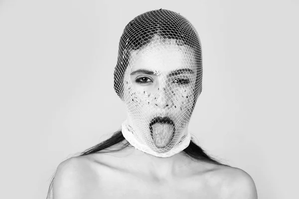 Girl showing tongue with white, fishnet stocking on head — Stock Photo, Image