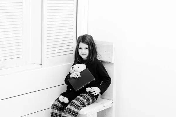 Cherful flicka sitter med anteckningsbok och Nalle — Stockfoto