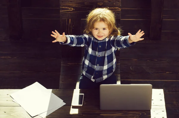 Garçon heureux enfant dans le bureau avec ordinateur portable, téléphone, feuille de papier — Photo