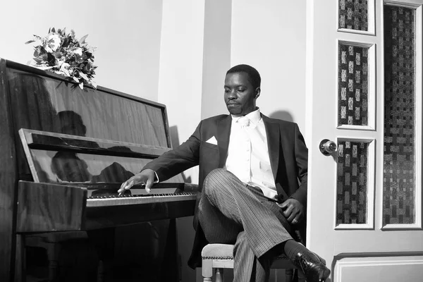 Красивий наречений грає на піаніно — стокове фото
