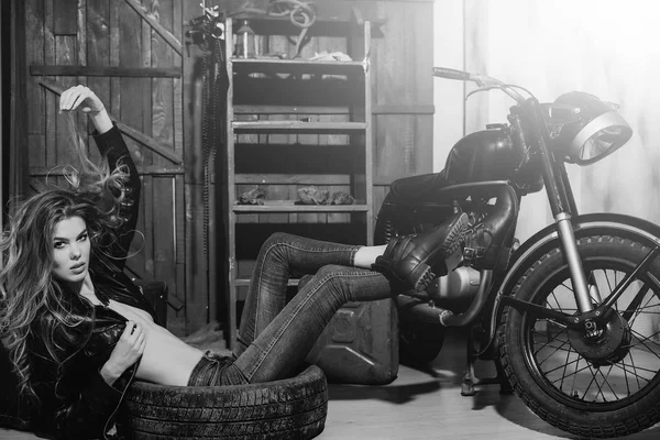 Girl lying in dirty rubber tire on floor — Stock Photo, Image