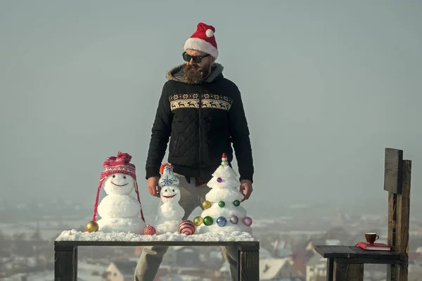 Man kijken sneeuwmannen en sneeuw kerstboom op tafel — Stockfoto