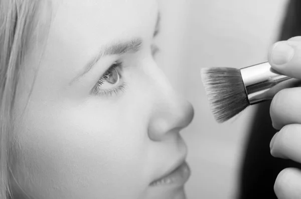 Chica conseguir polvo en la piel de la cara con cepillo de maquillaje — Foto de Stock
