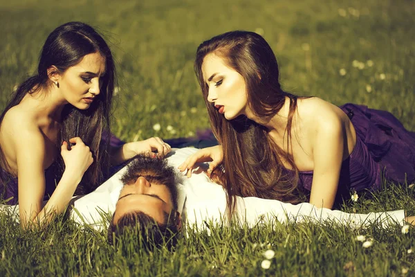 Barbudo hombre y dos mujeres en la hierba —  Fotos de Stock