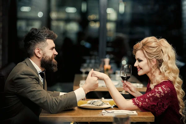 Красива молода пара тримає келихи шампанського і посміхається під час святкування в барі — стокове фото