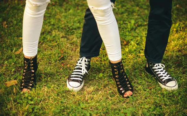 Livre para ser casual. Pernas femininas e masculinas em sapatos modernos. Sapatos femininos e femininos. Tendências da moda casual. As pernas humanas usam sapatos da moda para a juventude. Melhor estilo de moda de rua — Fotografia de Stock