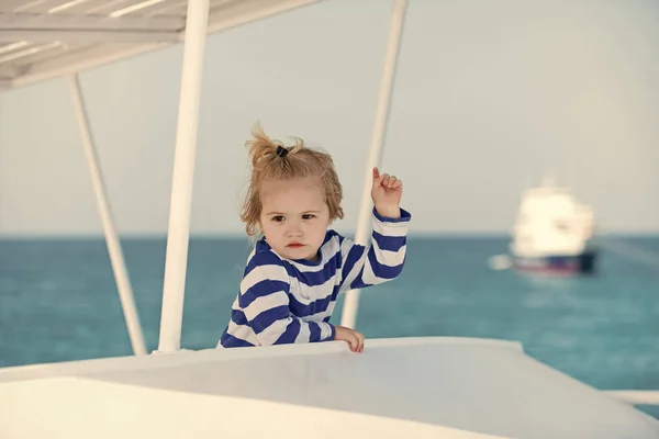 Dziecko w pasiastą koszulę ogląda niebieski ocean woda. — Zdjęcie stockowe