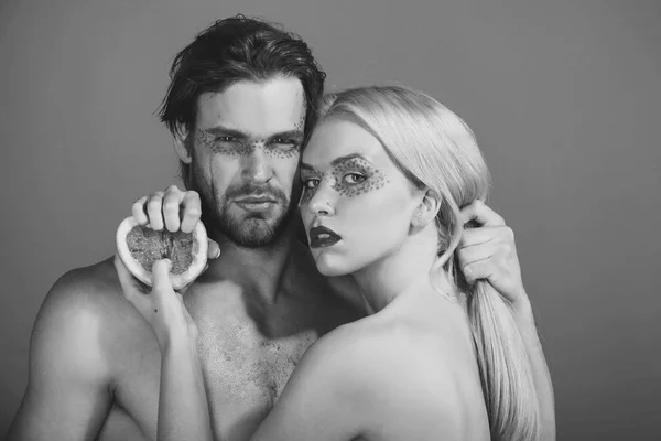 Młoda para kobieta i mężczyzna z makijażem przytrzymaj grejpfruta — Zdjęcie stockowe