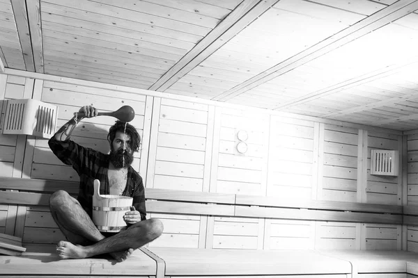 Красивый бородатый мужчина в деревянной ванне с ведром и ложкой — стоковое фото