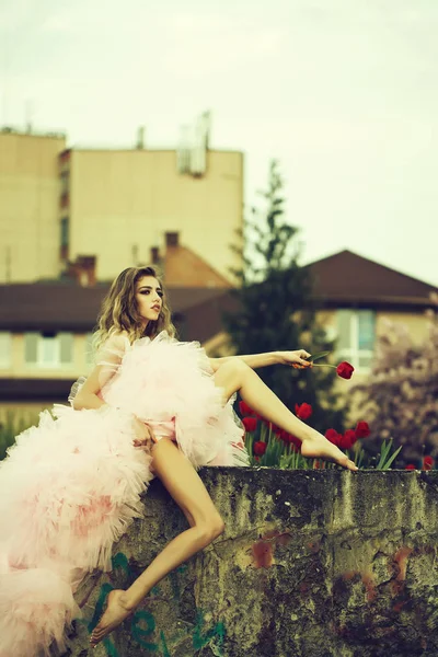 Mulher na moda perto de tulipas vermelhas — Fotografia de Stock