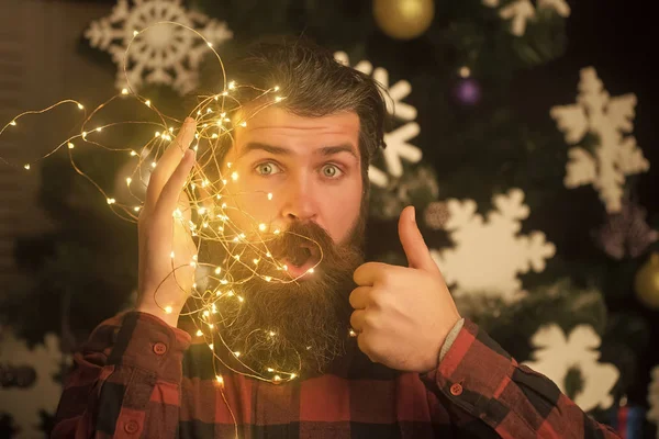 Christmas man with beard on surprised face and garland. — Stock Photo, Image
