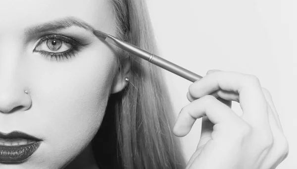 Frau halb Gesicht Zeichnung Augenbraue mit Make-up-Pinsel — Stockfoto