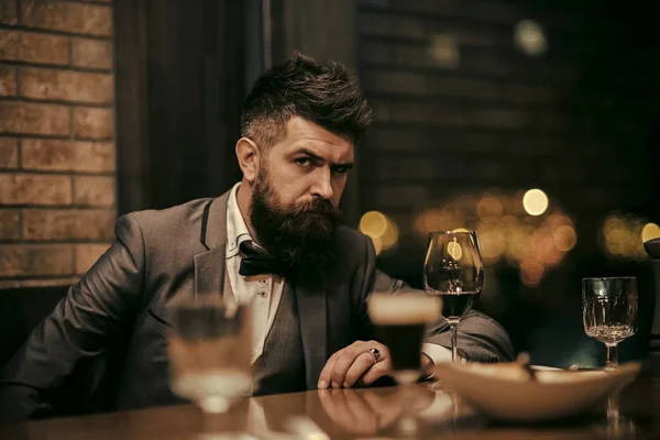 Porträt eines Geschäftsmannes mit einem Glas Champagner über dem Barhintergrund und Blick in die Kamera — Stockfoto