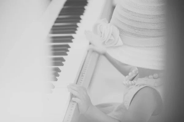 Niño en vintage sombrero rosa, vestido, collar de cuentas tocar el piano — Foto de Stock