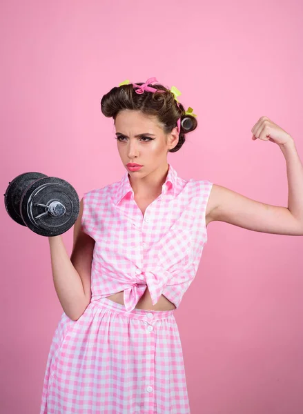 powerful housewife. pinup girl with fashion hair. retro woman with dumbbell. Sport. pin up woman with trendy makeup. pretty girl in vintage style. Getting stronger