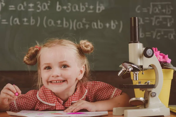 I bambini svolgono attività accademiche e di ricerca in classe. Ricerca bambina con microscopio nel laboratorio scolastico, filtro vintage — Foto Stock