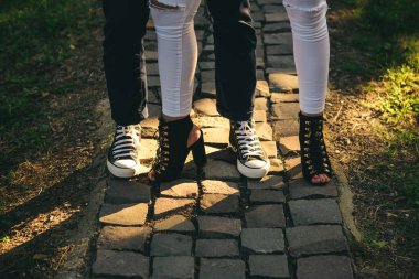 Topuklar ve daire. Kadın ve erkek ayakkabıları. Kadın ve erkek bacaklarda modern ayakkabılar. Rahat moda trendleri. İnsan ayakları gençler için moda trendy ayakkabılar giymek. En iyi sokak moda stil. Aktif için ayakkabı