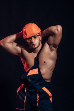 Tek yaptığım gurur duyuyoruz. Kendinden emin ve güçlü. Adam işçi kaslı seksi vücut ile. İnşaat işçisi veya Oluşturucu. Yakışıklı işçi veya işçi. Kaslı adam giyim kask ve üniforma
